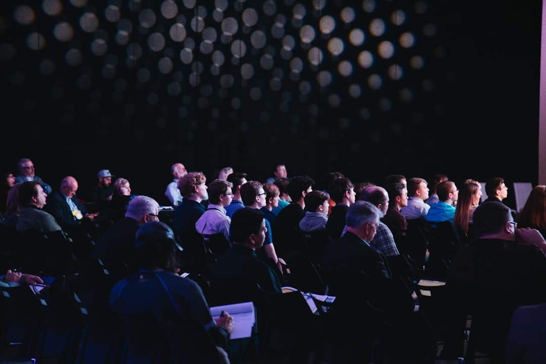 Conference room in Portland with projection screen, podium microphone, and rows of seated attendees