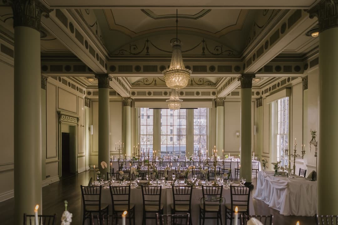 Elegant gala ballroom with projection screen, uplighting, and podium microphone setup
