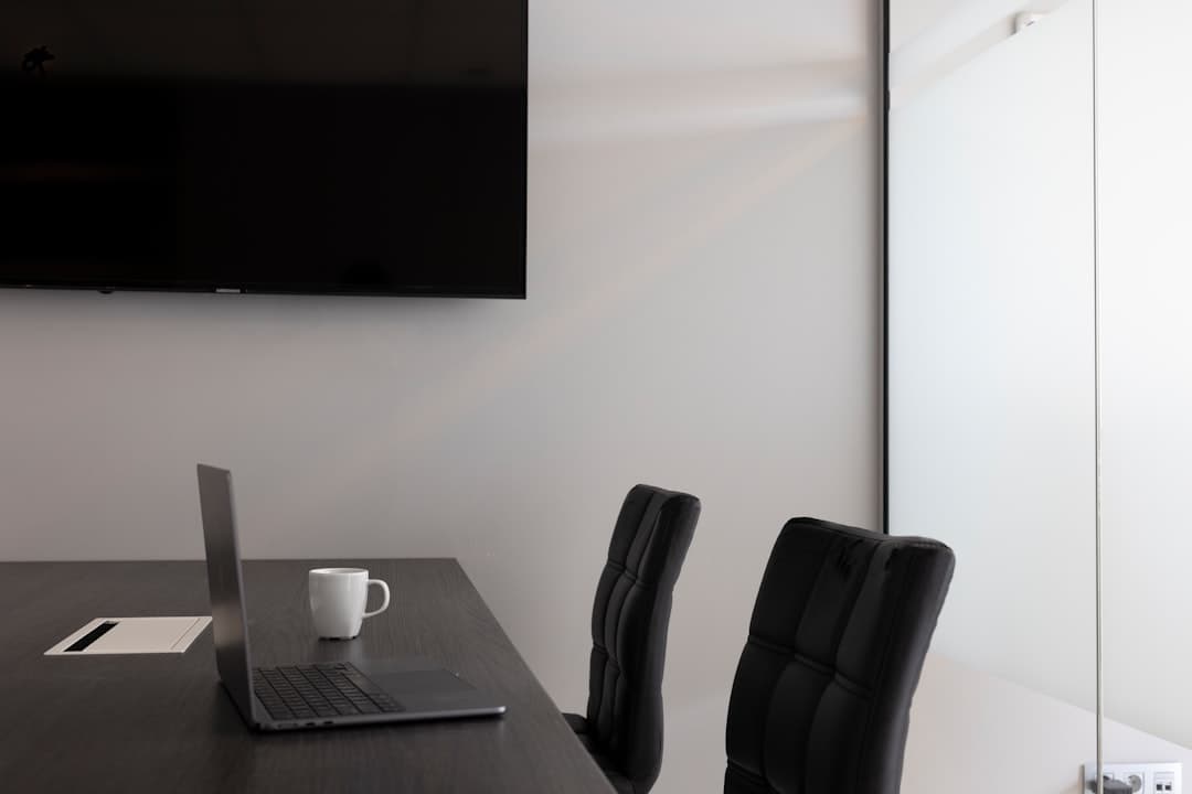 Large projection screen displaying presentation slides in a Portland conference room with rows of seated attendees