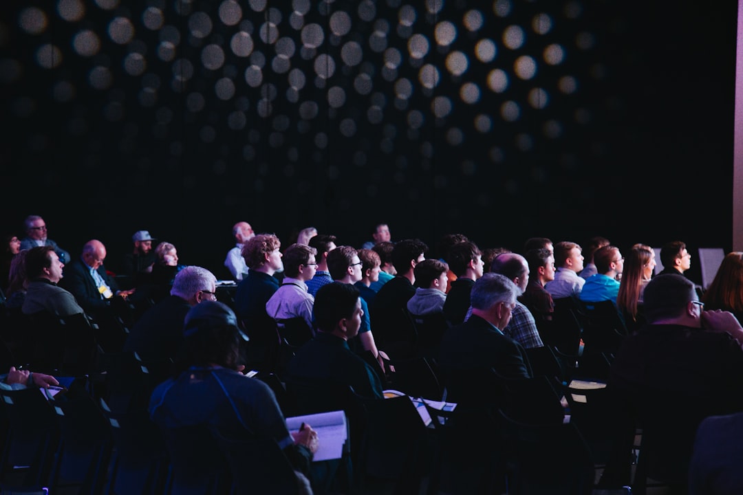 Conference room in Portland with projection screen, podium microphone, and rows of seated attendees